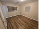 Simple bedroom with wood-look floors and two windows at 3414 Portersfield Rd, Orlando, FL 32808