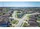 Aerial view showcasing a neighborhood with houses, roads, and a lake at 612 Chicago Way, Dundee, FL 33838