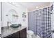 Bathroom with a granite vanity and checkered shower curtain at 612 Chicago Way, Dundee, FL 33838