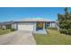 Cute one-story home with a yellow door, attached garage, and well-maintained lawn at 612 Chicago Way, Dundee, FL 33838