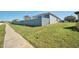 House side view, showcasing a wooden fence and landscaping at 612 Chicago Way, Dundee, FL 33838