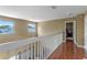 Upstairs hallway with wood floors and two windows at 4615 Cumbrian Lakes Dr, Kissimmee, FL 34746