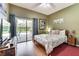 Bedroom with queen bed, sliding glass door to patio, and wood floors at 4615 Cumbrian Lakes Dr, Kissimmee, FL 34746