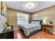 Bedroom with a queen bed, leafy bedding, and wood floors at 4615 Cumbrian Lakes Dr, Kissimmee, FL 34746