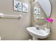 Small half bathroom with pedestal sink and oval mirror at 4615 Cumbrian Lakes Dr, Kissimmee, FL 34746