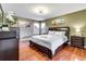Main bedroom with king bed and wood floors at 4615 Cumbrian Lakes Dr, Kissimmee, FL 34746