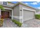 Two-car garage with a beige door and a paved driveway at 4615 Cumbrian Lakes Dr, Kissimmee, FL 34746