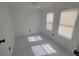 Bright bedroom with three windows and marble-look tile floors at 1058 N Davis Ave, Lakeland, FL 33805