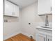 Bright laundry room with white cabinets and wood floors at 1716 Palmer Ave, Winter Park, FL 32789