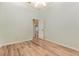 Spacious bedroom with light walls, wood-look floors, and access to another room at 24429 Madewood Ave, Leesburg, FL 34748