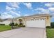 One-story house with a red door and two-car garage at 24429 Madewood Ave, Leesburg, FL 34748