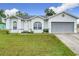 One-story house with gray garage and green lawn at 7713 Manor Dr, Lakeland, FL 33810