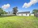 Spacious backyard with a large grassy area and home view at 7713 Manor Dr, Lakeland, FL 33810
