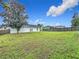 Large backyard with grassy area and partial home view at 7713 Manor Dr, Lakeland, FL 33810