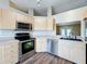 Modern kitchen with stainless steel appliances and wood-look flooring at 7713 Manor Dr, Lakeland, FL 33810