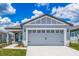 Two-car garage and light gray exterior with white accents at 3743 Bergamot St, Lake Alfred, FL 33850