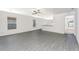 Spacious living room with grey wood-look flooring and access to kitchen at 3743 Bergamot St, Lake Alfred, FL 33850
