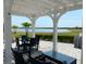 Spacious backyard patio with pergola, fire pit, and seating area, overlooking a lake at 4552 Sequel Rd, Kissimmee, FL 34746