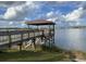 Covered pier overlooking a serene lake with surrounding homes at 4552 Sequel Rd, Kissimmee, FL 34746