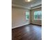 Bright living room featuring dark laminate flooring and large windows at 7952 Wandering Way, Orlando, FL 32836