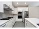 Modern white kitchen with stainless steel appliances and quartz countertops at 7737 Somersworth Dr, Kissimmee, FL 34747