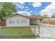 Tan house with carport, fenced yard, and mature trees at 910 N Lincoln Ave, Lakeland, FL 33815