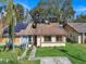 Tan house with brown roof, solar panels, and a small front yard at 1057 Old South Dr, Lakeland, FL 33811