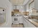Small kitchen with white cabinets and granite countertops at 1057 Old South Dr, Lakeland, FL 33811