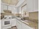 Small kitchen with white cabinets and granite countertops at 1057 Old South Dr, Lakeland, FL 33811