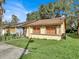 Tan house with brown roof, solar panels, and a small front yard at 1057 Old South Dr, Lakeland, FL 33811