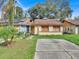 Tan house with brown roof, solar panels, and a small front yard at 1057 Old South Dr, Lakeland, FL 33811