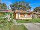 Tan house with brown roof, solar panels, and a small front yard at 1057 Old South Dr, Lakeland, FL 33811