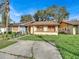 Tan house with brown roof, solar panels, and a small front yard at 1057 Old South Dr, Lakeland, FL 33811