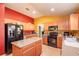 Kitchen with wood cabinets, an island, and black appliances at 4067 Sw 46Th Ter, Ocala, FL 34474