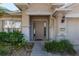 Beige house exterior with a brown door, landscaping, and a walkway at 4067 Sw 46Th Ter, Ocala, FL 34474