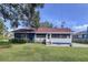 Cute blue house with red roof, screened porch, and large yard at 1938 E Fern Rd, Lakeland, FL 33801