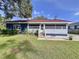 A charming single story home with blue exterior and red roof, surrounded by a well maintained lawn at 1938 E Fern Rd, Lakeland, FL 33801