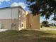 Side view of a two-story house with tan and white siding at 5018 Strada Dr, Winter Haven, FL 33880