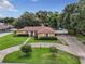 Single story home with circular driveway, landscaping, and attached garage at 2002 Amesbury Dr, Auburndale, FL 33823