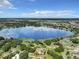Aerial view of lakefront property with homes and lush landscaping at 2002 Amesbury Dr, Auburndale, FL 33823