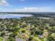 Wide aerial view of a lakefront neighborhood with lush green spaces and lake views at 2002 Amesbury Dr, Auburndale, FL 33823