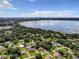 Aerial view of a lakefront neighborhood featuring numerous homes, trees, and tranquil water views at 2002 Amesbury Dr, Auburndale, FL 33823