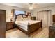 Main bedroom with king-size bed and wood floors at 2002 Amesbury Dr, Auburndale, FL 33823