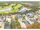 Aerial view of a house next to a golf course and lake at 3366 Cat Brier Trl, Harmony, FL 34773