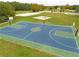 Community basketball court with two hoops and green and blue surface at 3366 Cat Brier Trl, Harmony, FL 34773