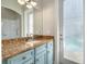 Bathroom with light blue vanity, granite countertop and walk-in shower at 3366 Cat Brier Trl, Harmony, FL 34773