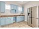 Light blue cabinets, granite countertops, and stainless steel appliances in a spacious butler's pantry at 3366 Cat Brier Trl, Harmony, FL 34773