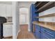 Laundry room with blue cabinets, granite countertops, and built-in shelving at 3366 Cat Brier Trl, Harmony, FL 34773