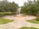 Circular water fountain feature in a park with benches and trees at 3366 Cat Brier Trl, Harmony, FL 34773