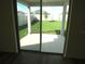 View of a grassy backyard with a patio from sliding glass doors at 148 Summerlin Loop, Haines City, FL 33844